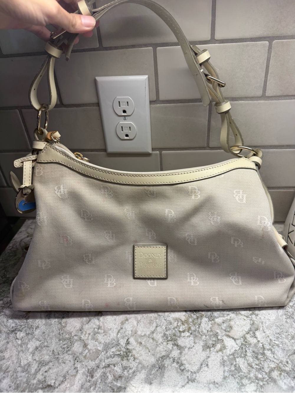 Dooney & Bourke Small East West Slouch Bag in an ivory/beige